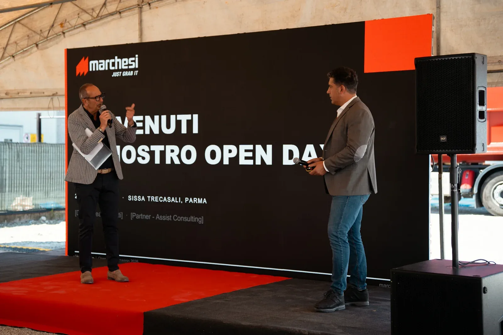 Due relatori con microfoni sul palco
