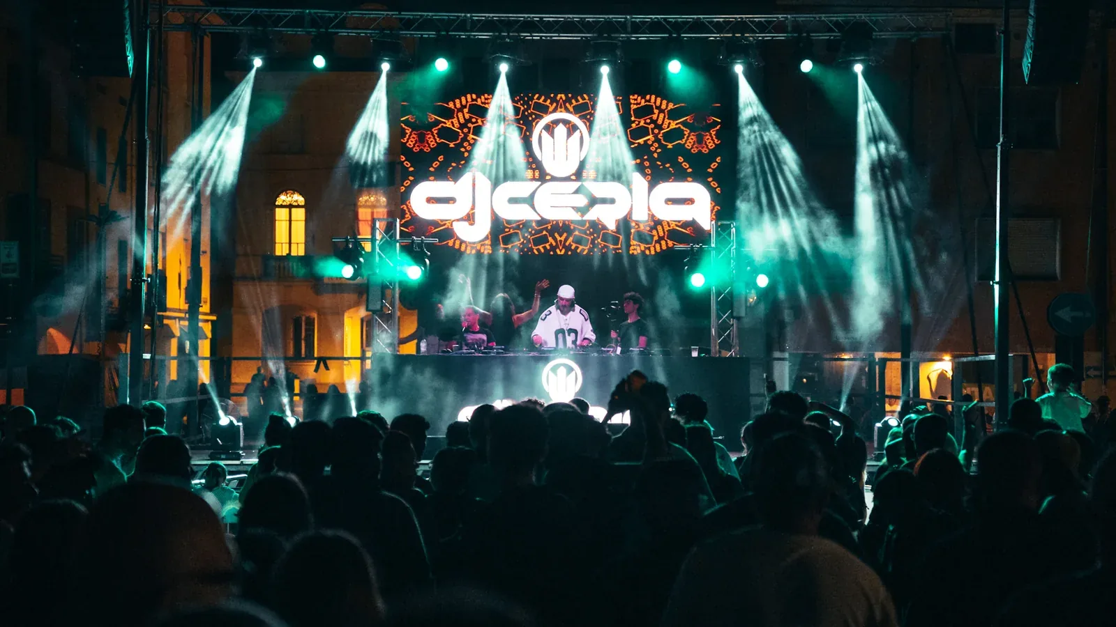 Pubblico in piazza davanti a un palco illuminato