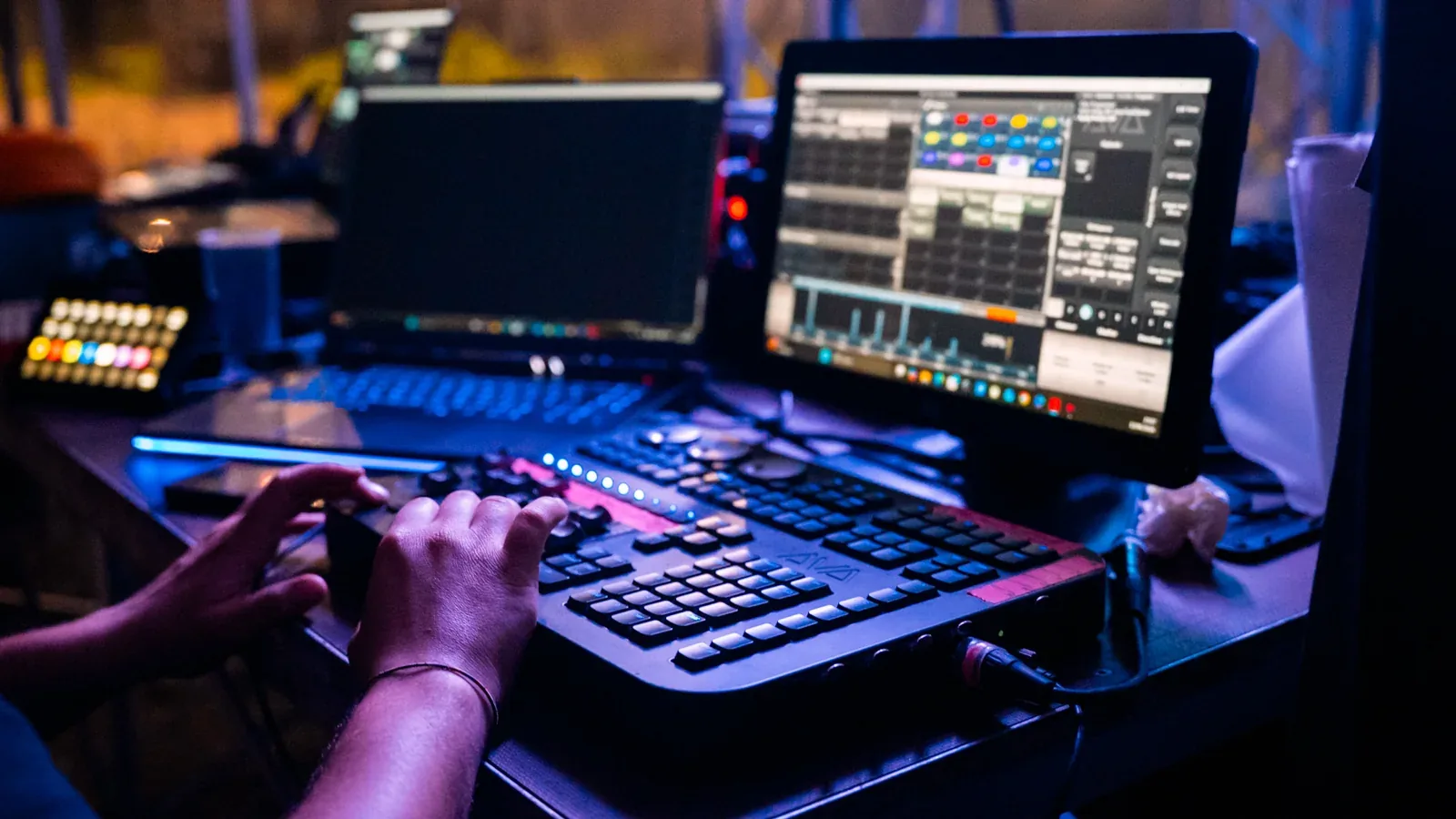 Regia tecnica durante un evento, con mixer e computer